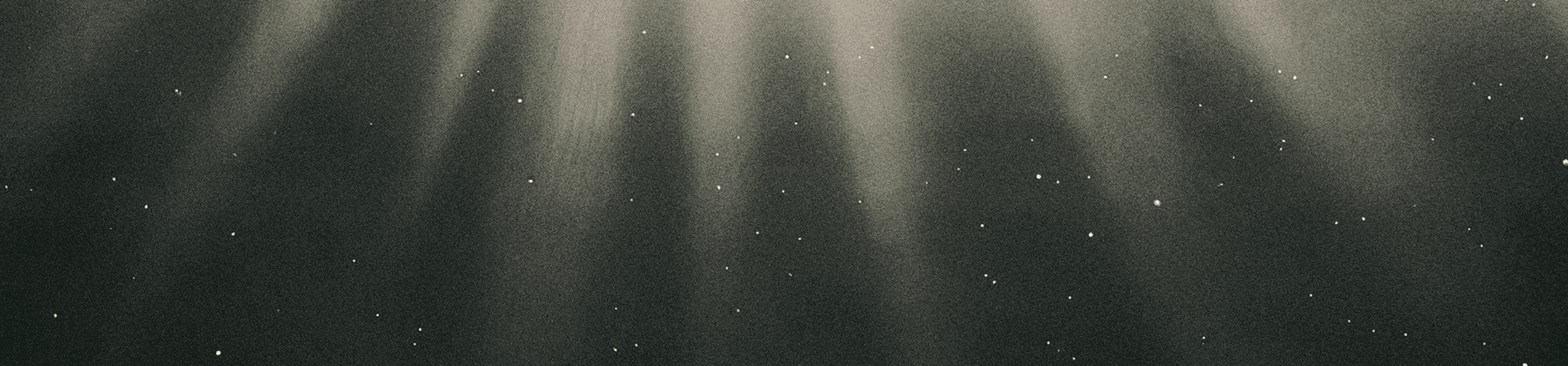 Dark background with beams of light and scattered white dots, resembling underwater light rays or a starry night sky.